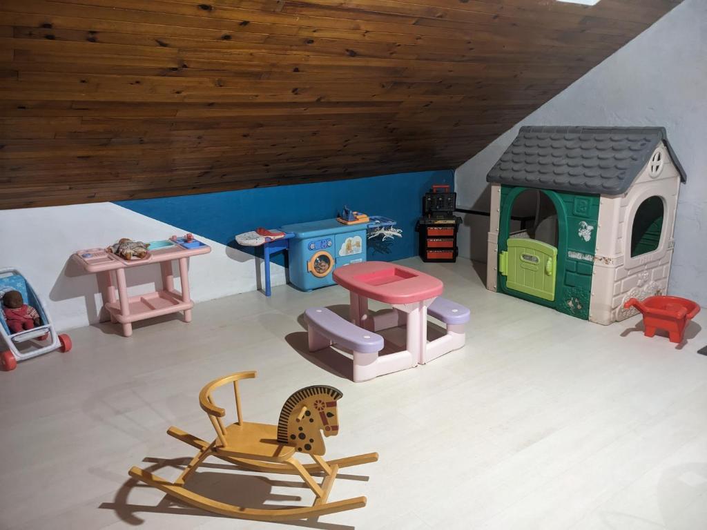 ein Spielzeugzimmer mit einem Spielhaus und einem Stuhl in der Unterkunft Appartement et salle de jeu in Saint-Claude