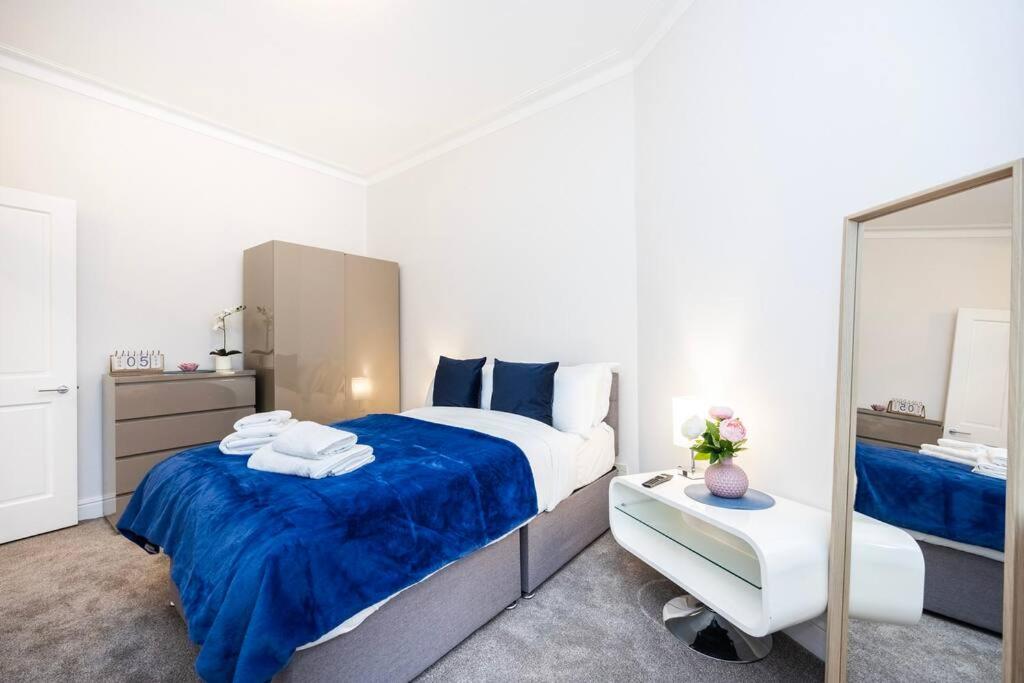 een slaapkamer met een groot bed en een spiegel bij Stylish Studio in Leicester Square in Londen