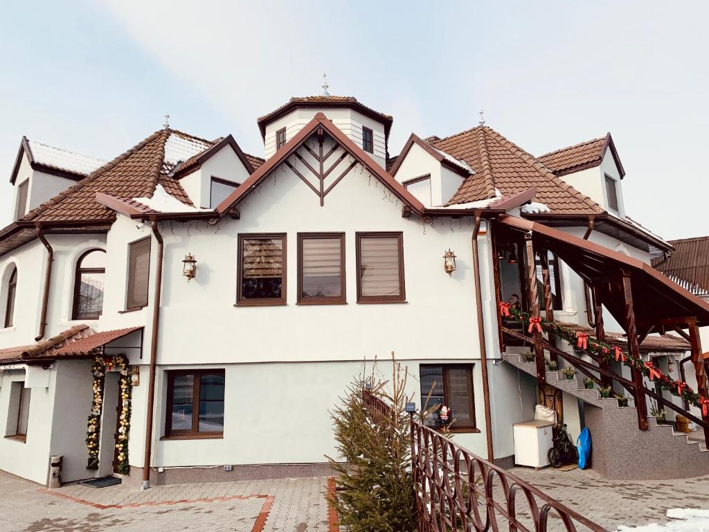 a white house with a brown roof at Casa Lazar in Topliţa