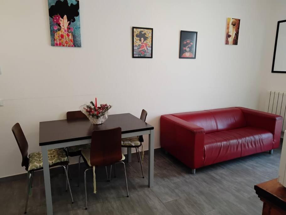 sala de estar con mesa y sofá rojo en Toni di Rosa, Tavullia centro en Tavullia