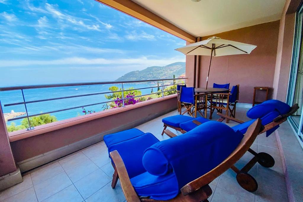 a balcony with chairs and a table and a view of the ocean at Magnifiques appartements vue mer panoramique in Théoule-sur-Mer