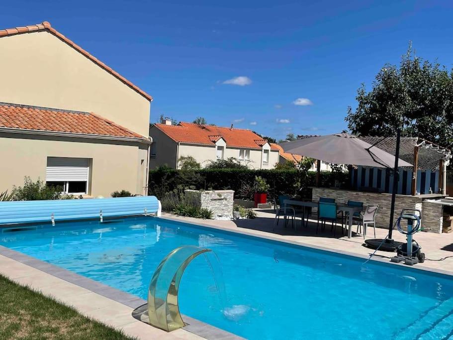 a swimming pool in the backyard of a house at Charmant T1 privé avec vue et accès piscine in Basse-Goulaine