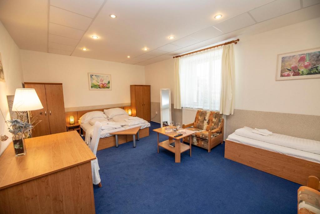 a hospital room with two beds and a table at Hotel Allvet in Drnovice