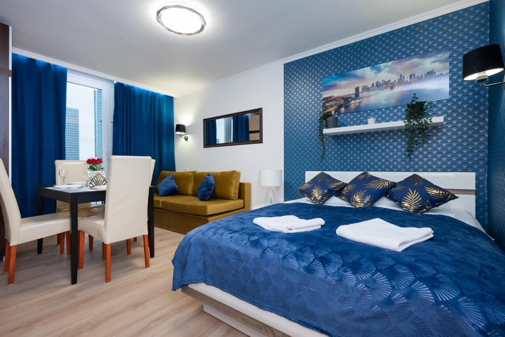 um quarto com uma cama azul e uma sala de jantar em UnitApartament Warszawa Centrum Room in Apartment by Metro Rondo ONZ Super wygodne noclegi zapraszamy em Varsóvia