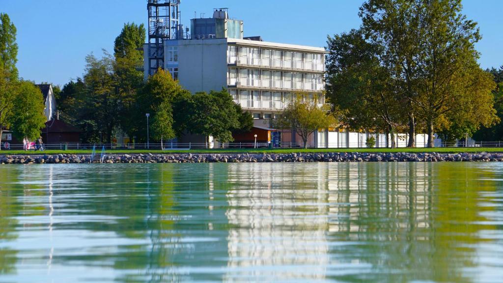 duży zbiornik wody z budynkiem w tle w obiekcie Plazs Hotel Siófok w Siófoku