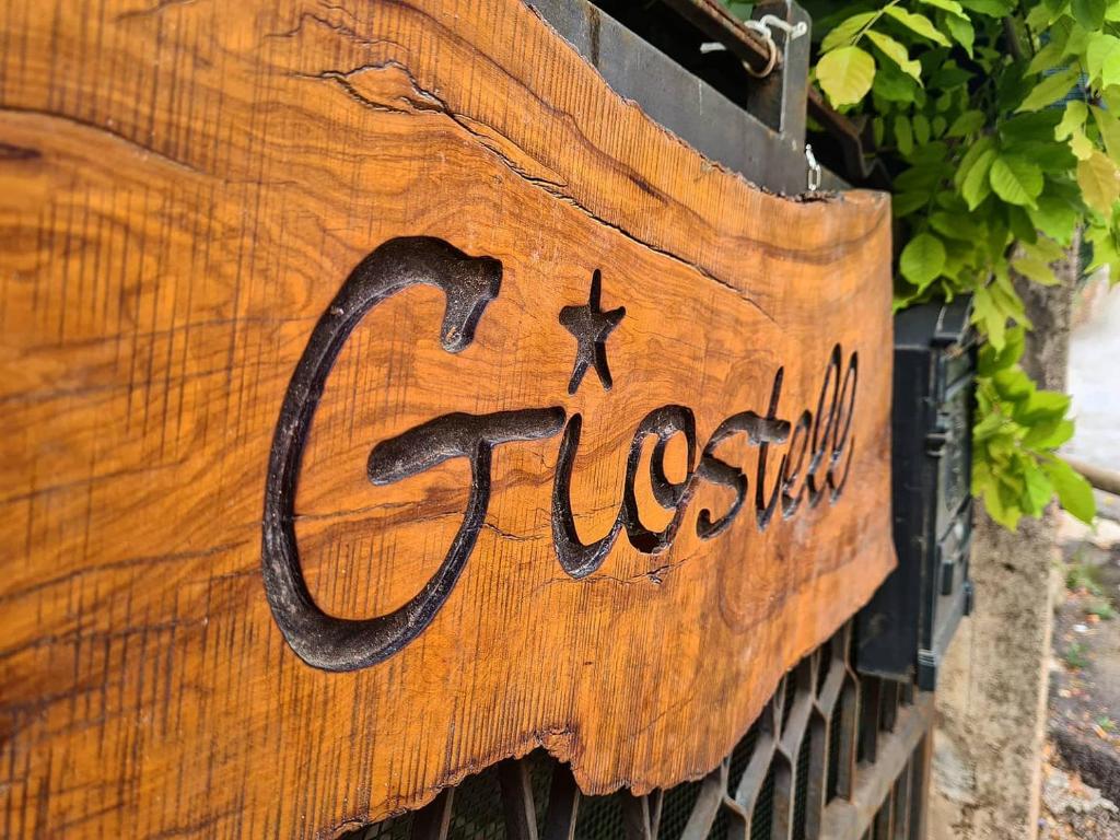 a wooden sign that says gossitz on a wall at B&B Giostell in Marina di Camerota