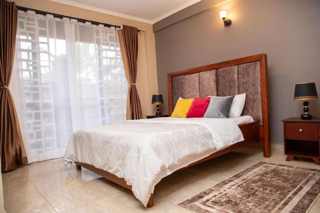 1 dormitorio con cama grande y ventana grande en Azarel homes, en Kampala