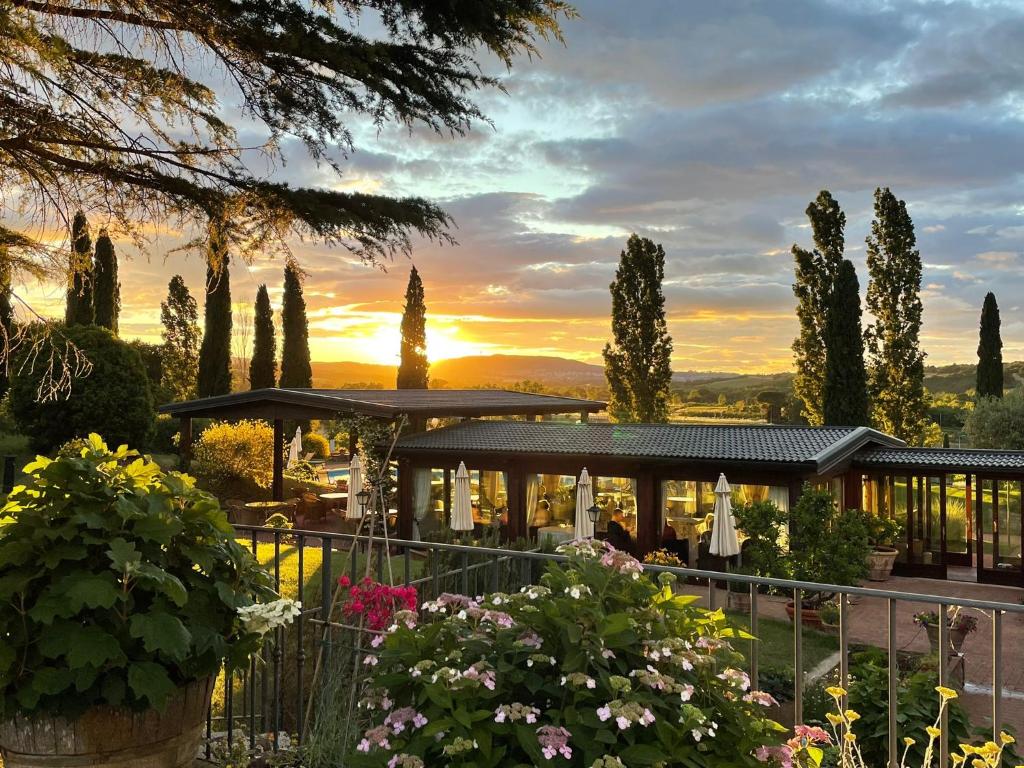 uma vista para um edifício com árvores e flores em Agriturismo La Sovana em Sarteano