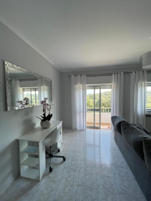 een woonkamer met een wit bureau en een bank bij Casa Sol Nascente in Silves