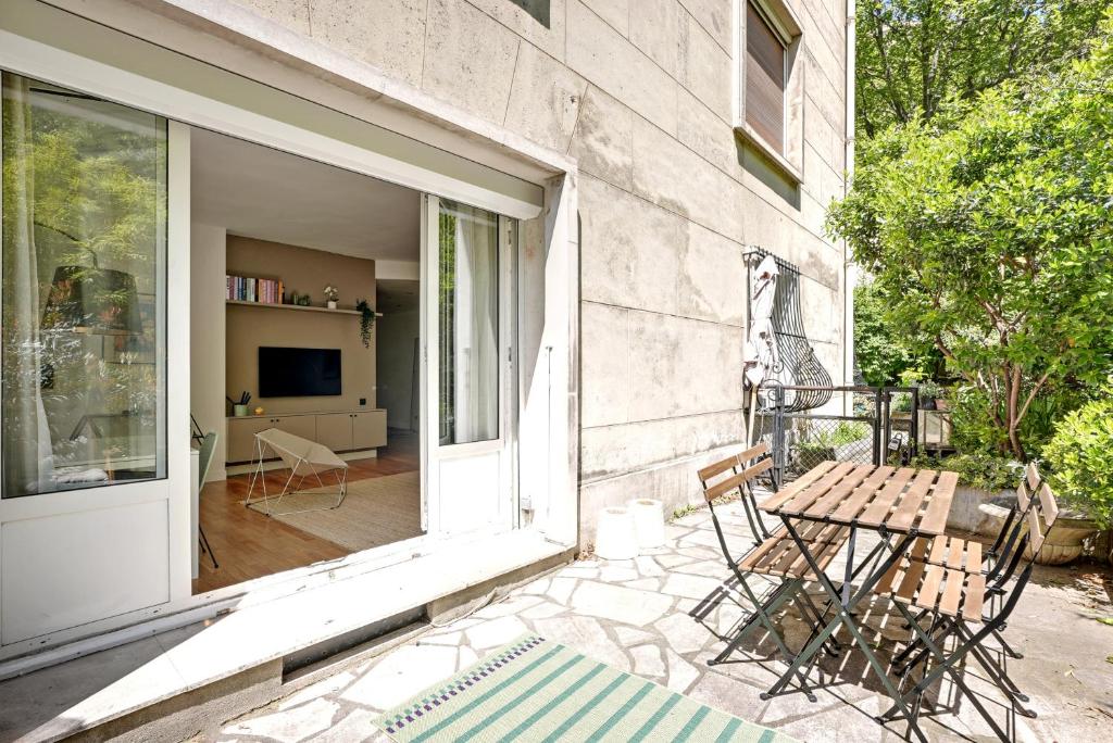 a patio with a table and chairs on a balcony at Appartement cozy 2 Beds Ranelagh in Paris