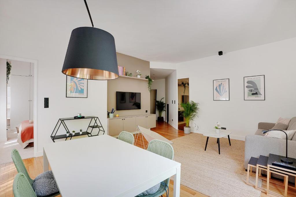a kitchen and living room with a white table and chairs at Appartement cozy 2 Beds Ranelagh in Paris