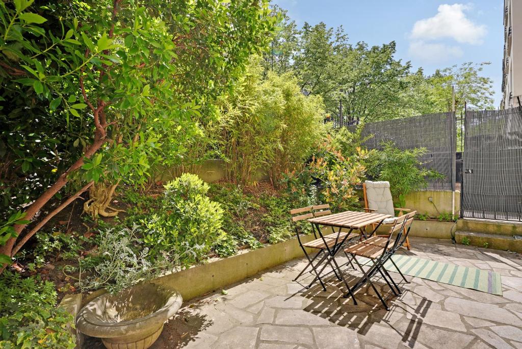 a patio with a table and chairs in a garden at Appartement cozy 2 Beds Ranelagh in Paris