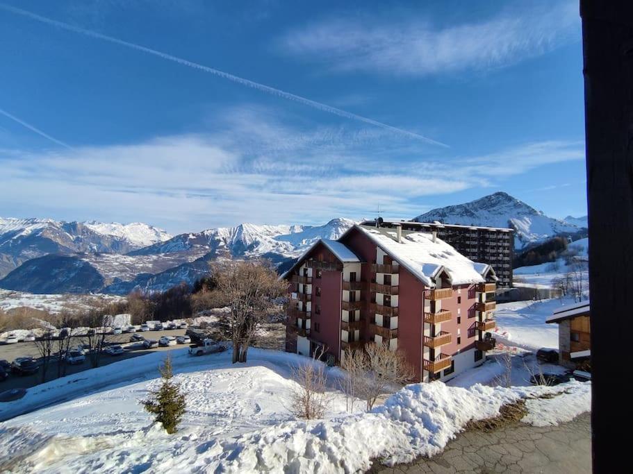 a building in the snow with mountains in the background at Appartement Le Corbier, 3 pieces, 7 personnes, au pied des pistes in Villarembert
