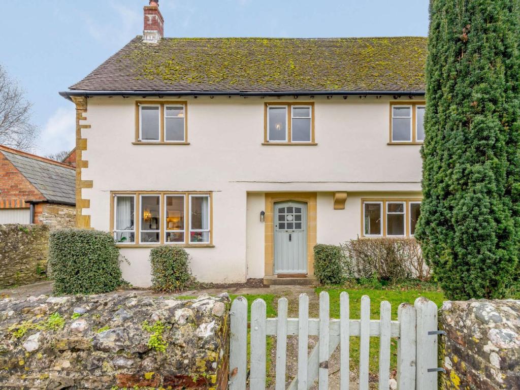 a white house with a white picket fence at 3 Bed in Cerne Abbas 74803 in Cerne Abbas