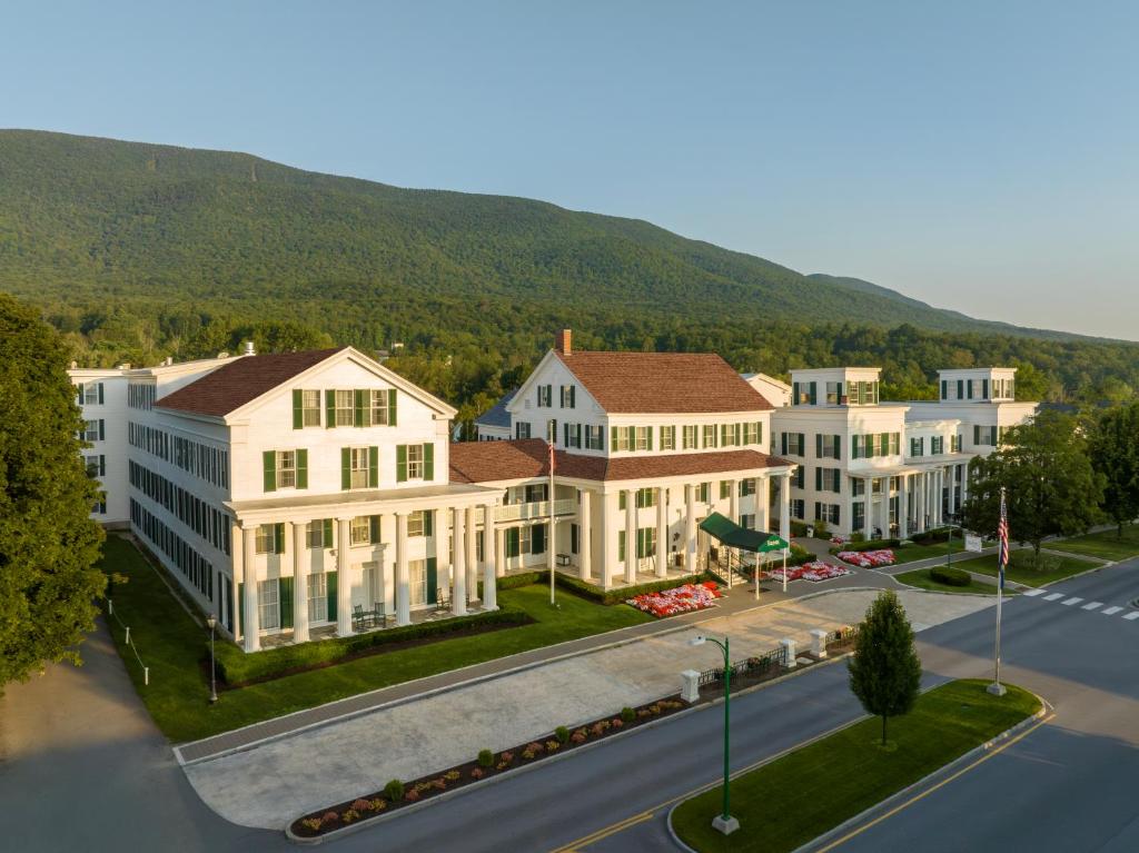 an aerial view of a building with a mountain in the background at The Equinox Golf Resort & Spa in Manchester