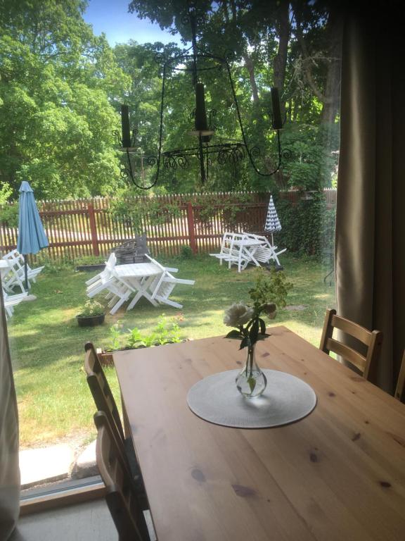 a wooden table with a vase with flowers on it at Marmorcafets B&B in Kolmården