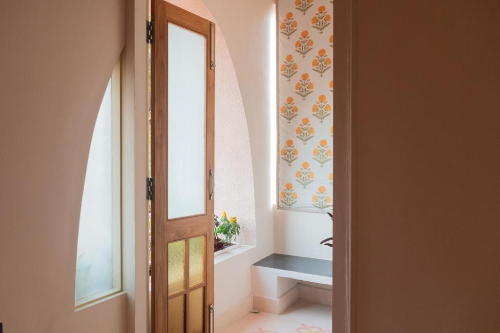 a bathroom with a toilet and a window and a door at Rajan House in Jaipur
