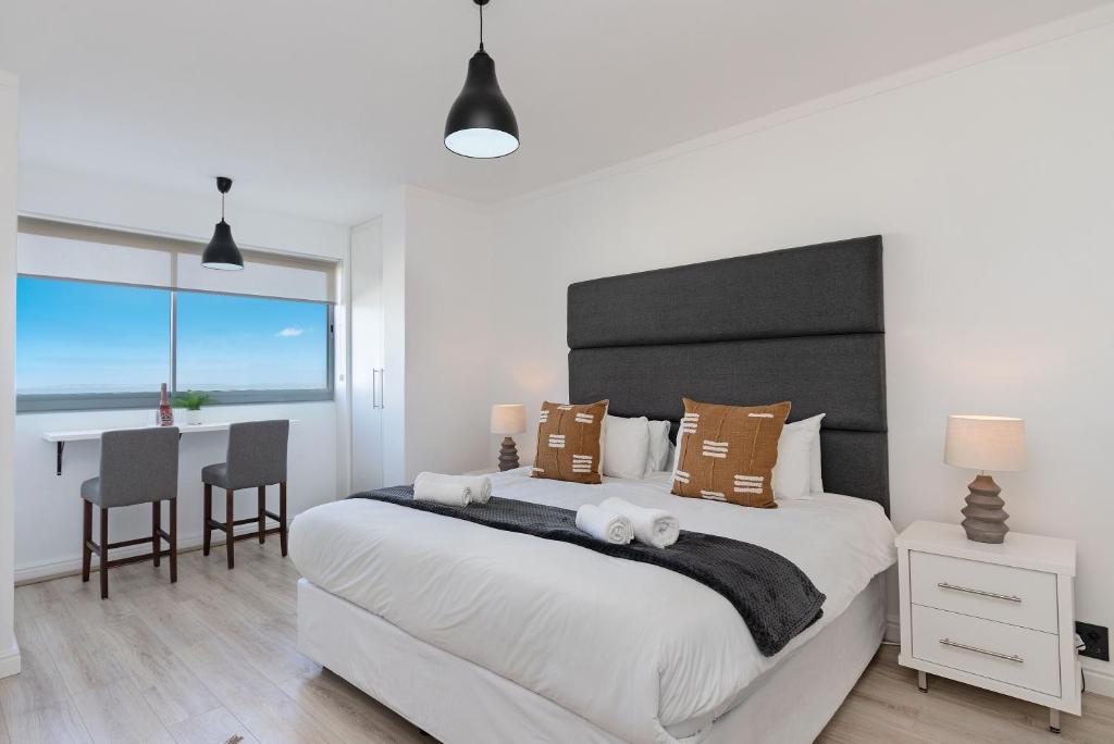 a bedroom with a large bed and a table with chairs at Blouberg Heights 207 in Bloubergstrand