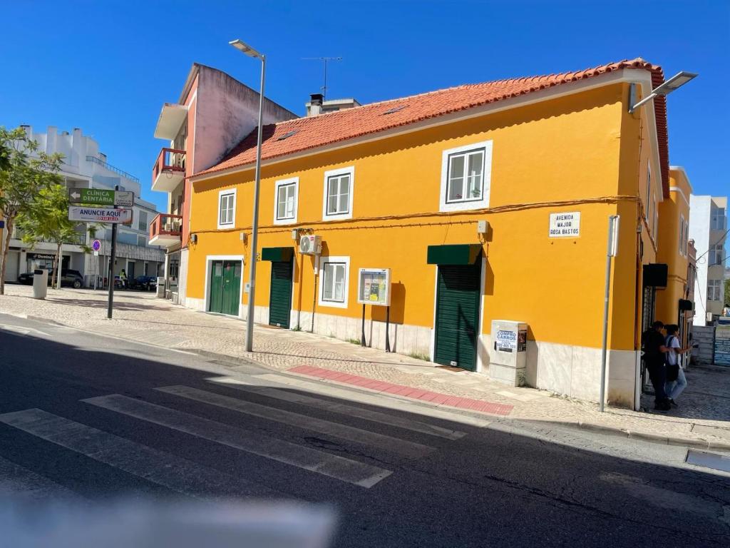 a yellow building on the side of a street at Matching Loures Guest House in Loures