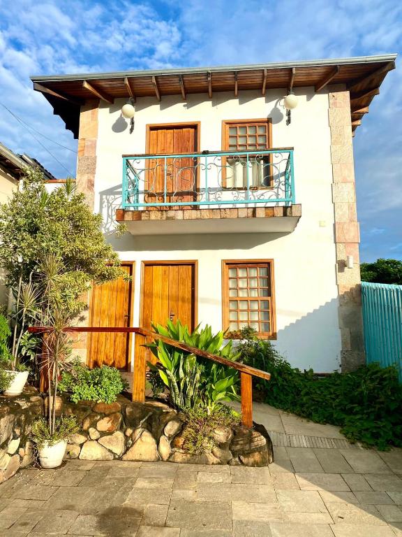 a house with a balcony on top of it at Quinta Da Estalagem in Pirenópolis