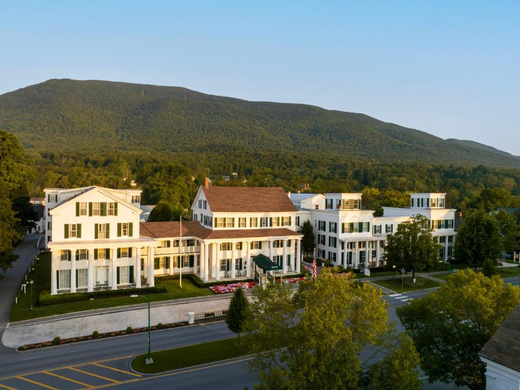 a group of white buildings with a mountain in the background at The Equinox Golf Resort & Spa in Manchester