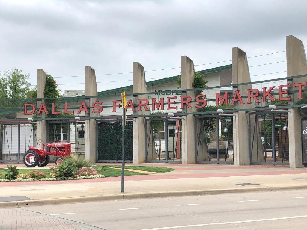 a building with a sign for a farmers market at Dallas Farmers Market Area, Just right in Downtown in Dallas