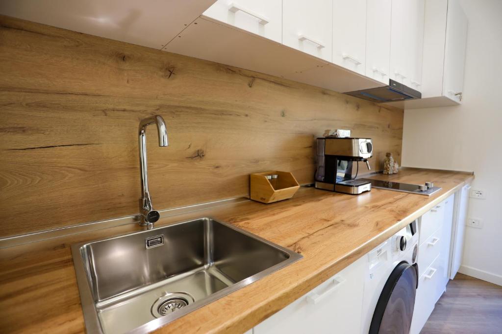 a kitchen with a sink and a wooden counter top at Doraci apartments in Tirana