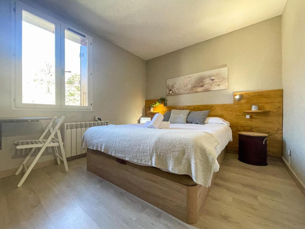 - une chambre avec un grand lit et une fenêtre dans l'établissement Apartamento ideal para parejas en Enveitg, à Enveitg