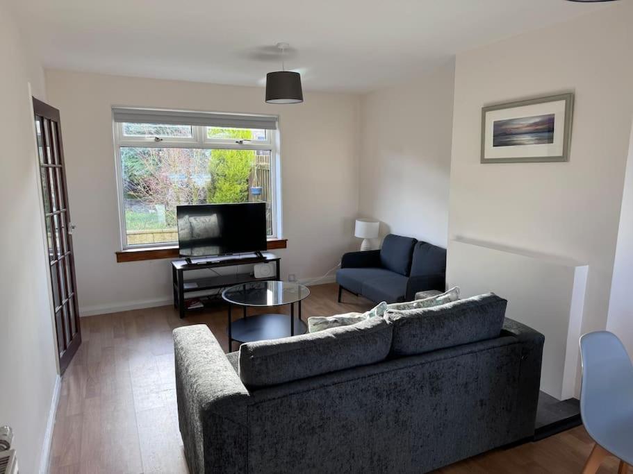 a living room with a couch and a tv at 4 Bed House, Glenrothes sleeps 5 in Fife