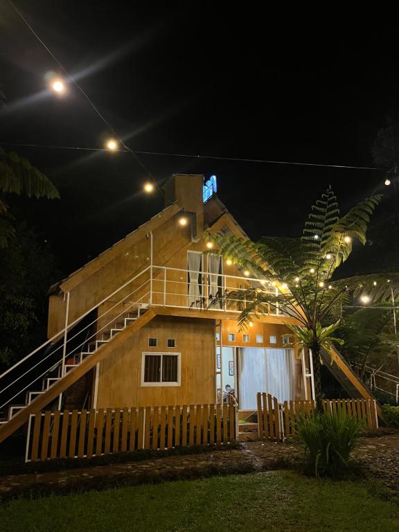 Una casa de noche con luces encendidas. en Villa Kolah Watu en Wonosobo