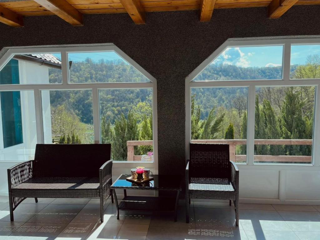 two chairs and a table in a room with windows at Holiday Home Aladin's in Bihać