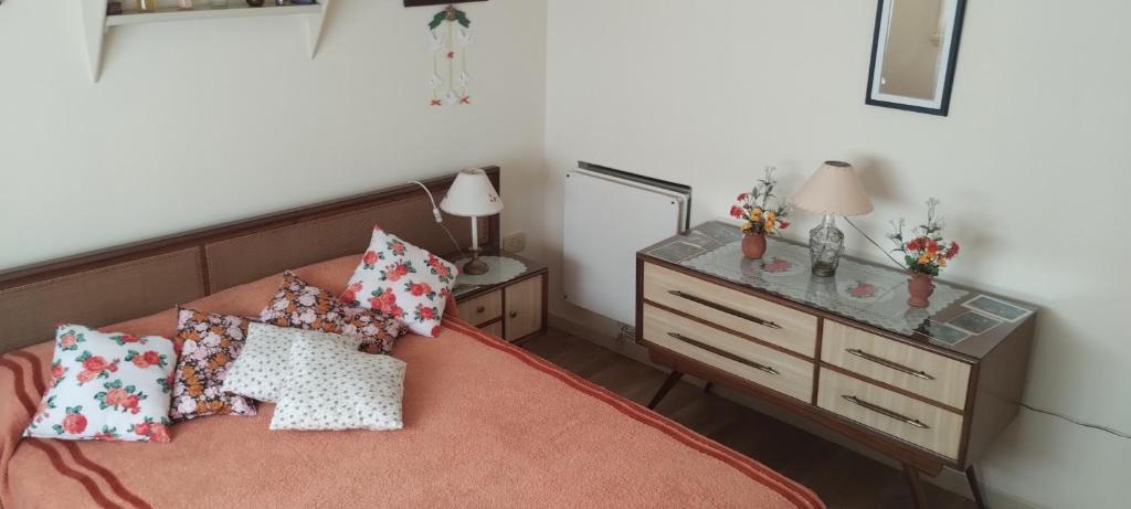 1 dormitorio con 1 cama con almohadas y vestidor en La perla y el mar en Mar del Plata