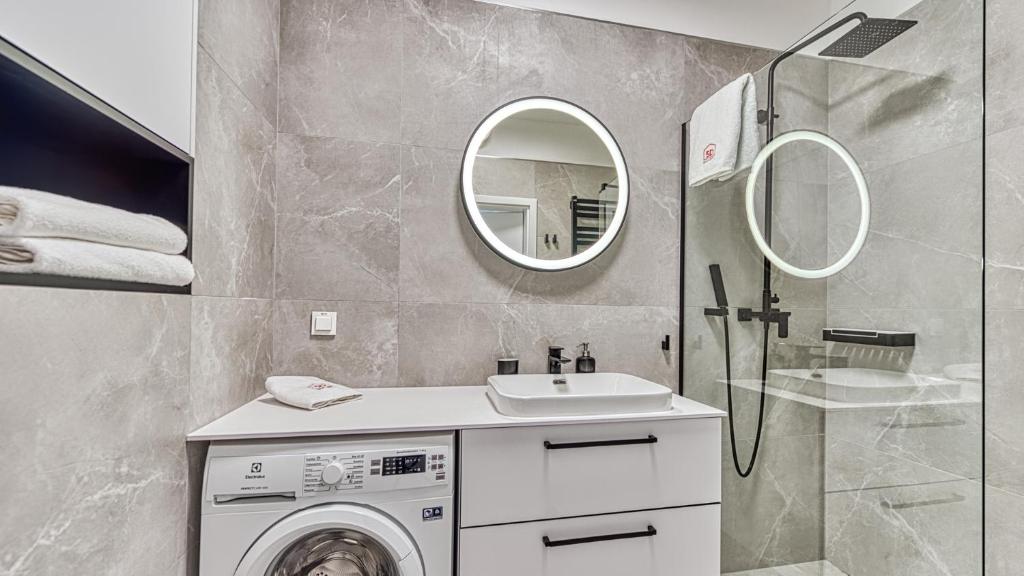 W łazience znajduje się pralka i lustro. w obiekcie Rezydencja Niechorze 328 - 5D Apartamenty w mieście Niechorze