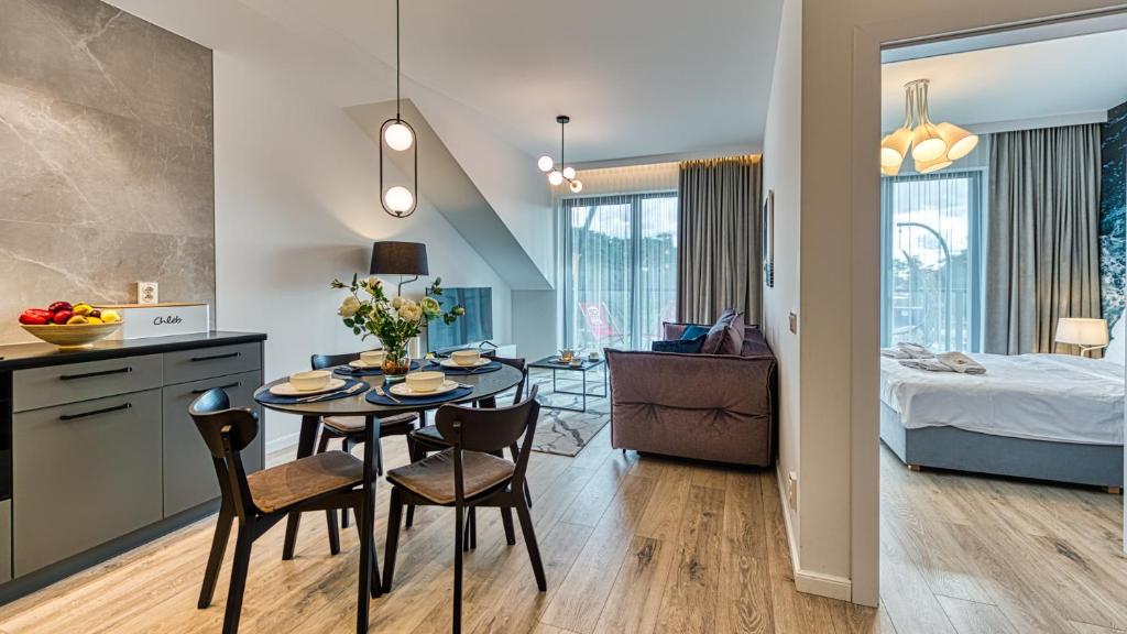 kuchnia i salon ze stołem i krzesłami w obiekcie Rezydencja Niechorze 328 - 5D Apartamenty w mieście Niechorze