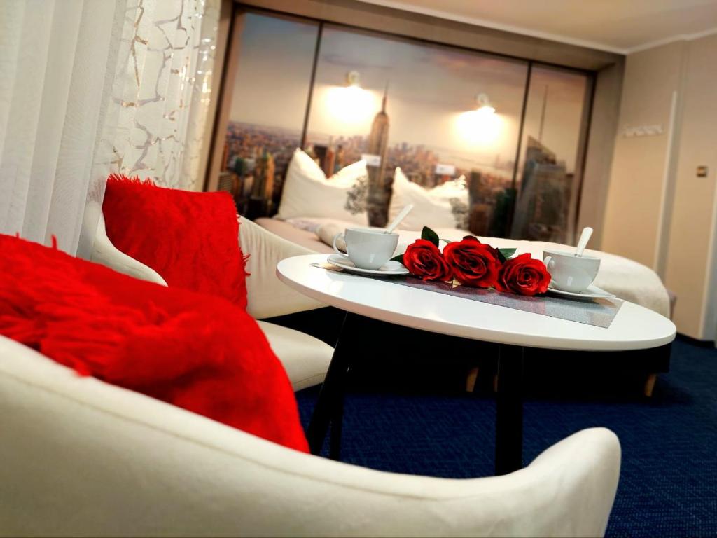 a hotel room with a table with two roses on it at HORTENSJA 304 in Koszalin