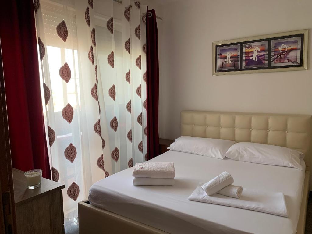 ein Schlafzimmer mit einem Bett mit zwei Handtüchern darauf in der Unterkunft Quartz Apartament in Durrës
