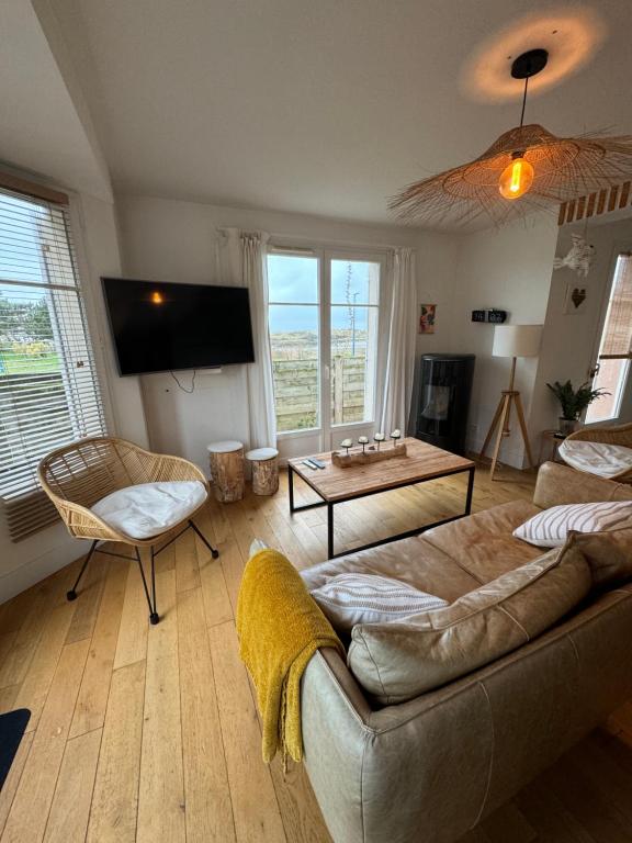 een woonkamer met een bank en een tafel bij Maison port guillaume in Dives-sur-Mer