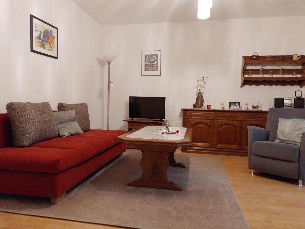 sala de estar con sofá rojo y mesa en Fuchs, en Eslohe
