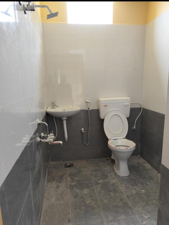 een badkamer met een toilet en een wastafel bij Pearl Guest House in Chennai