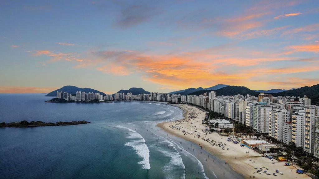 une vue aérienne d'une plage avec des bâtiments et l'océan dans l'établissement Vista incrível Beira-Mar Espaçoso 4 Qts AC, à Guarujá