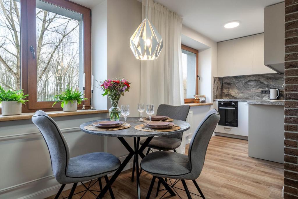 cocina y comedor con mesa y sillas en VAVA apartment, en Klaipėda