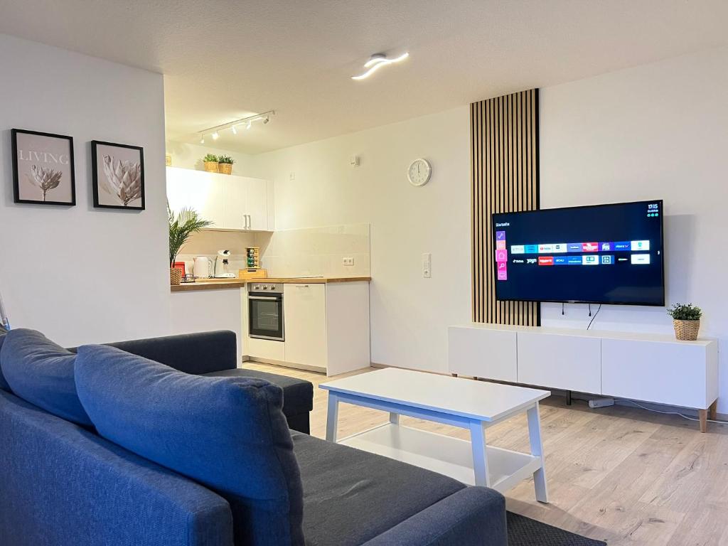 uma sala de estar com um sofá azul e uma televisão em Apartment Leverkusen em Leverkusen