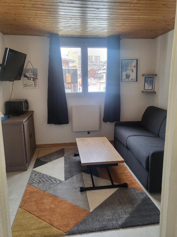 un salon avec un canapé et une table dans l'établissement Appartement 4 personnes ski aux pieds, à Les Deux Alpes