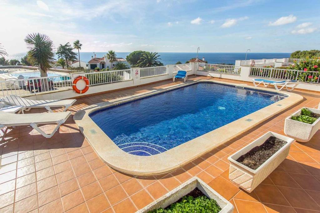 a swimming pool on a patio next to the ocean at Villa Anita in Santo Tomás