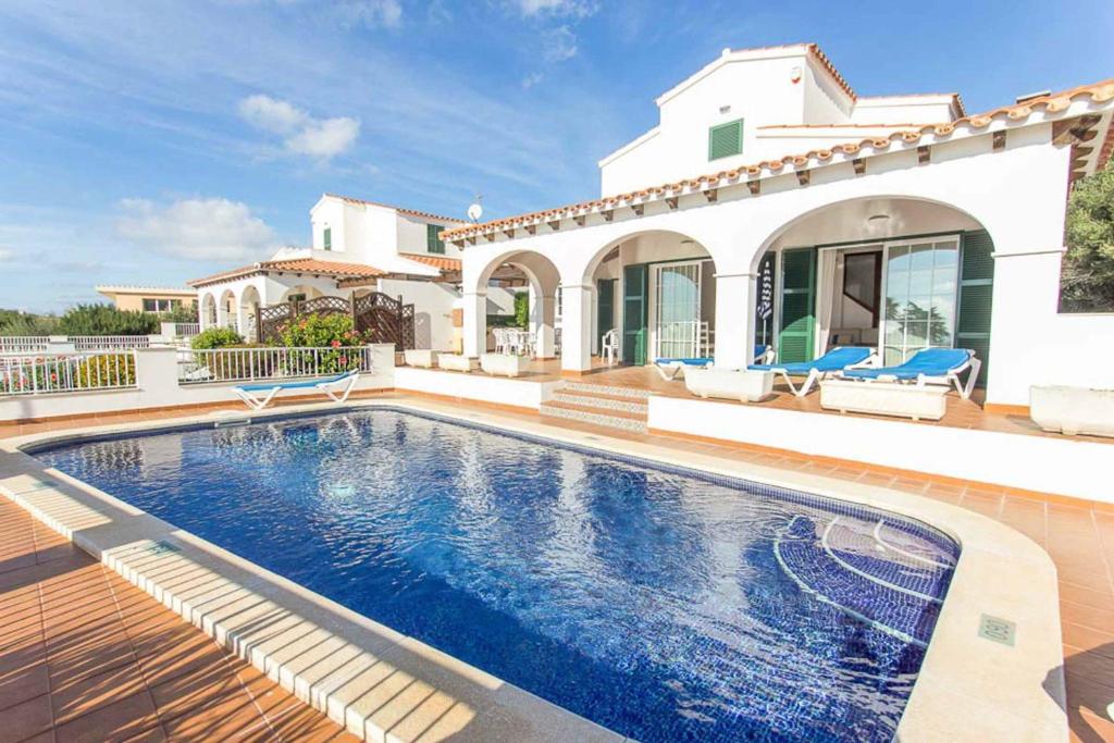 una villa con piscina frente a una casa en Villa Anita, en Santo Tomás