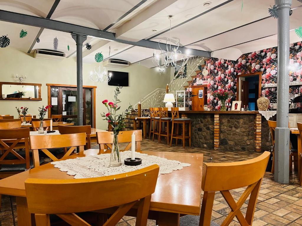 un restaurante con mesas de madera, sillas y flores en la pared en Maciejowa Chata, en Pobiedziska