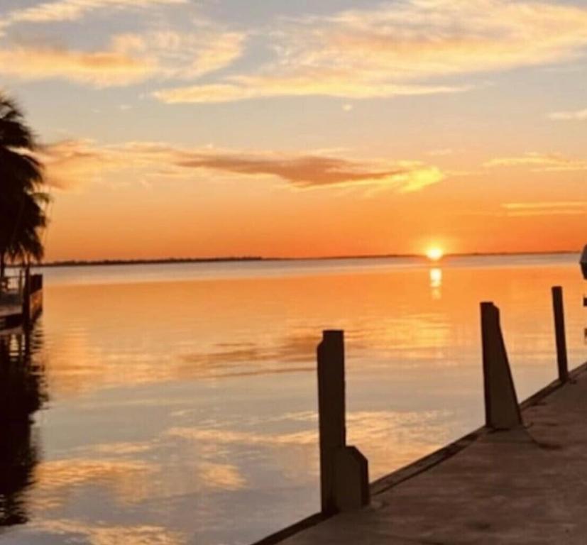 zachód słońca nad wodą z dokiem w obiekcie Green world zone in Calusa w mieście Key Largo