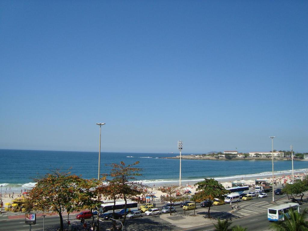 een parkeerplaats naast het strand met bussen geparkeerd bij Alex Rio Flats Studio Beach View in Rio de Janeiro