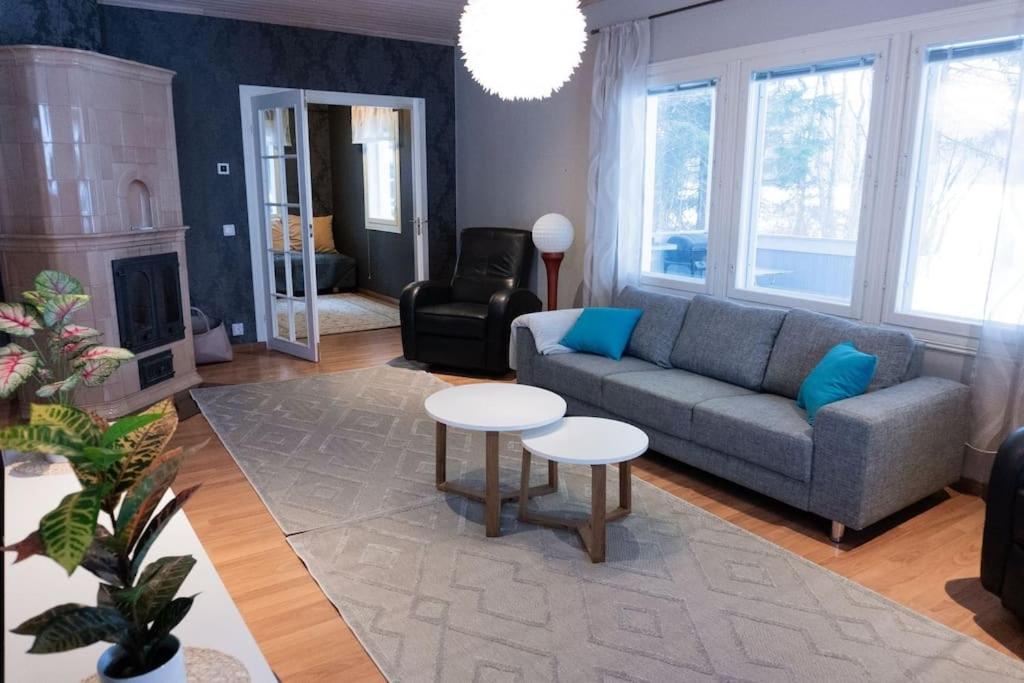 een woonkamer met een bank en een tafel bij Villa Ylämylly in Joensuu