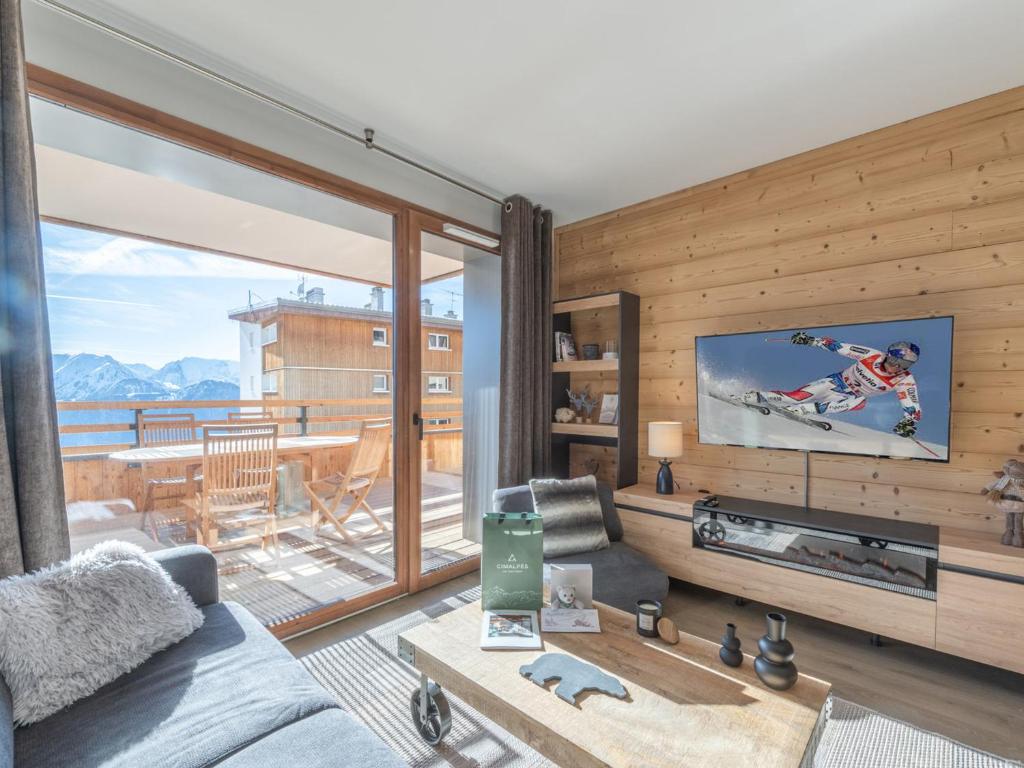 a living room with a couch and a flat screen tv at Appartement lumineux avec parking, proche des pistes à Alpe d'Huez - FR-1-645-62 in LʼHuez